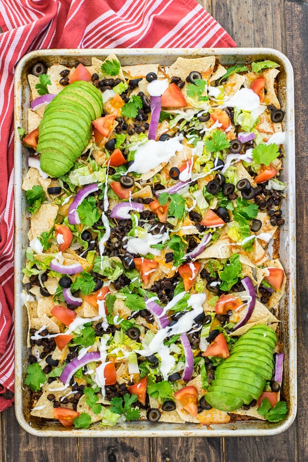 overhead shot of seasoned black bean nachos on a sheet pan 