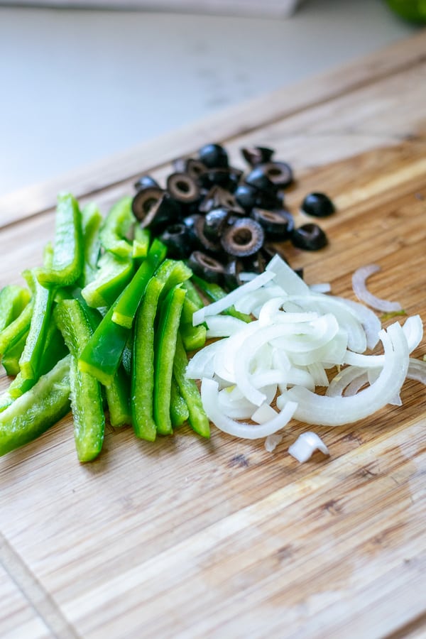 toppings for the chicken on a cutting board