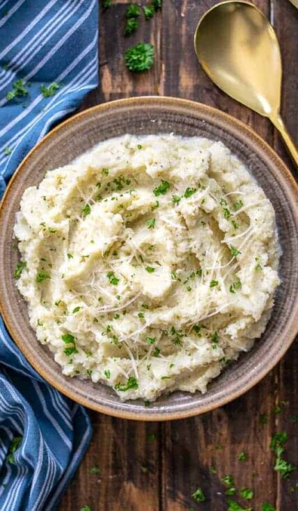 bowl of garlic parmesan mashed cauliflower on a wood table