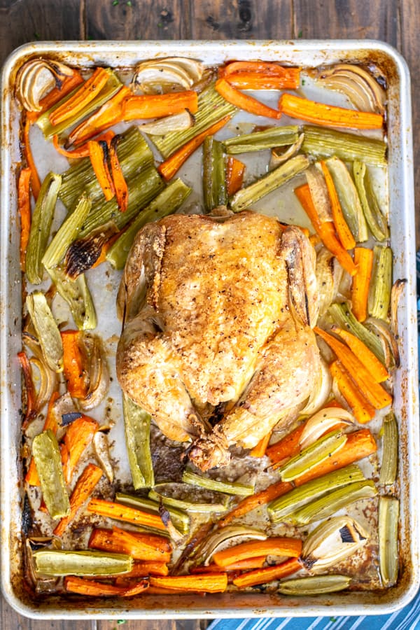 freshly cooked chicken on a sheet pan with vegetables