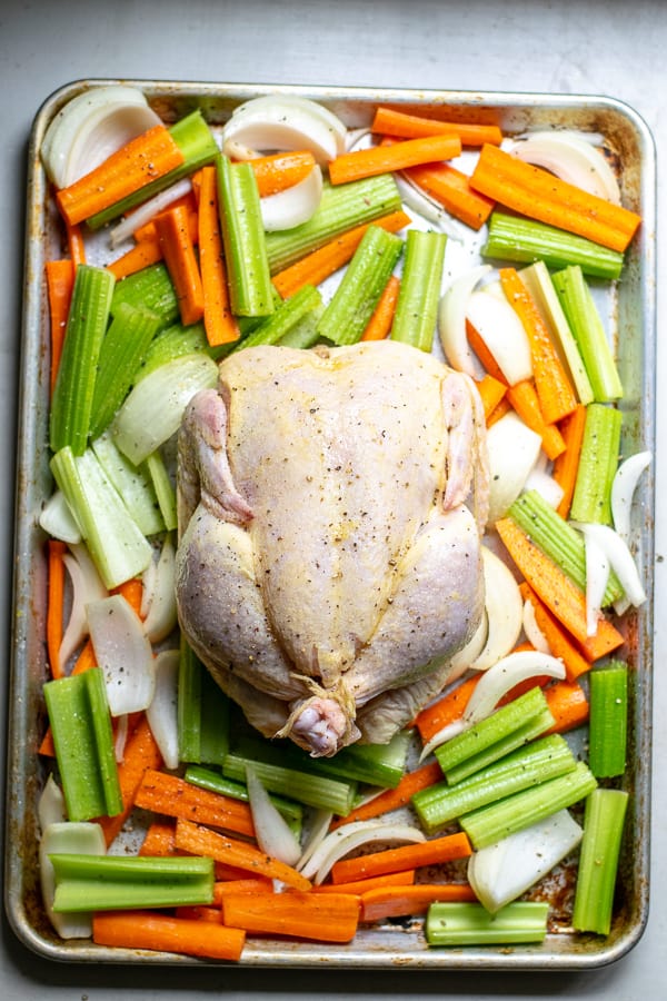 sheet pan with vegetables and raw chicken