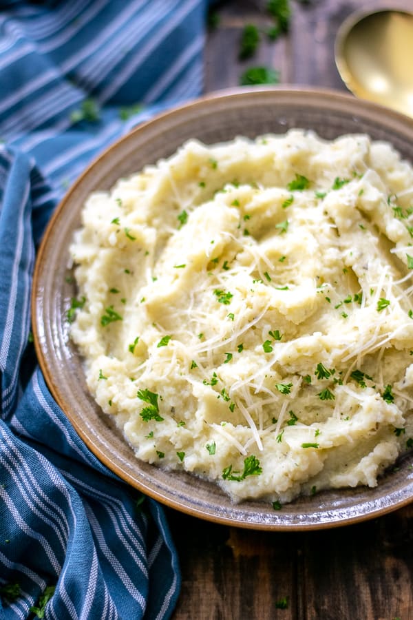 Garlic Parmesan Mashed Cauliflower in a bowl with parsley 