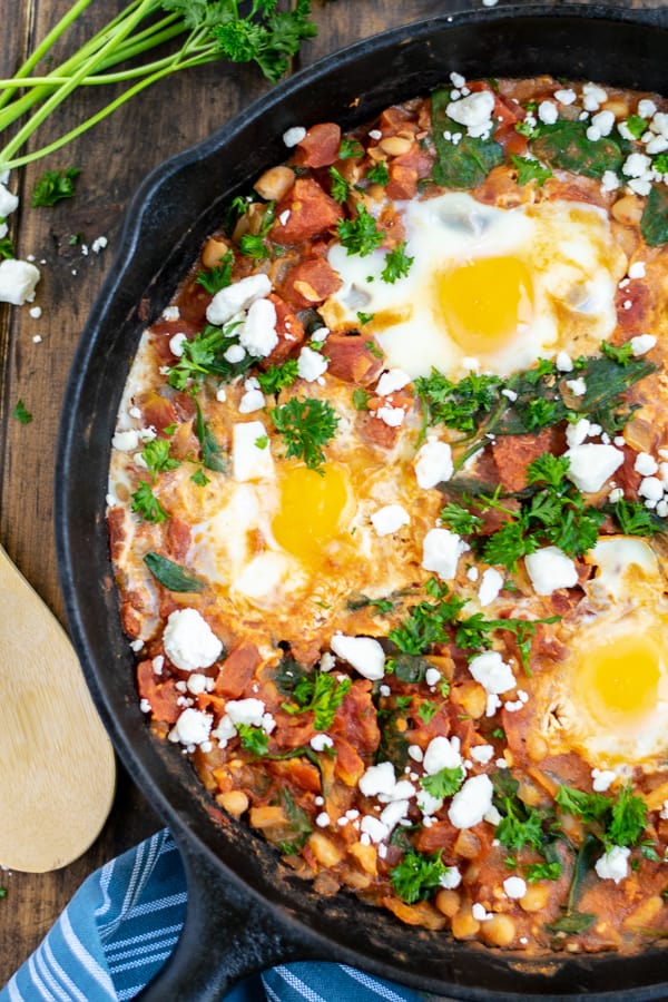 close up of cooked shakshuka with eggs in a cast iron skillet