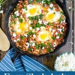 shakshuka with spinach in a cast iron skillet with a blue towel, feta, and parsley