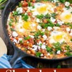 cast iron skillet holding a shakshuka with spinach and white beans