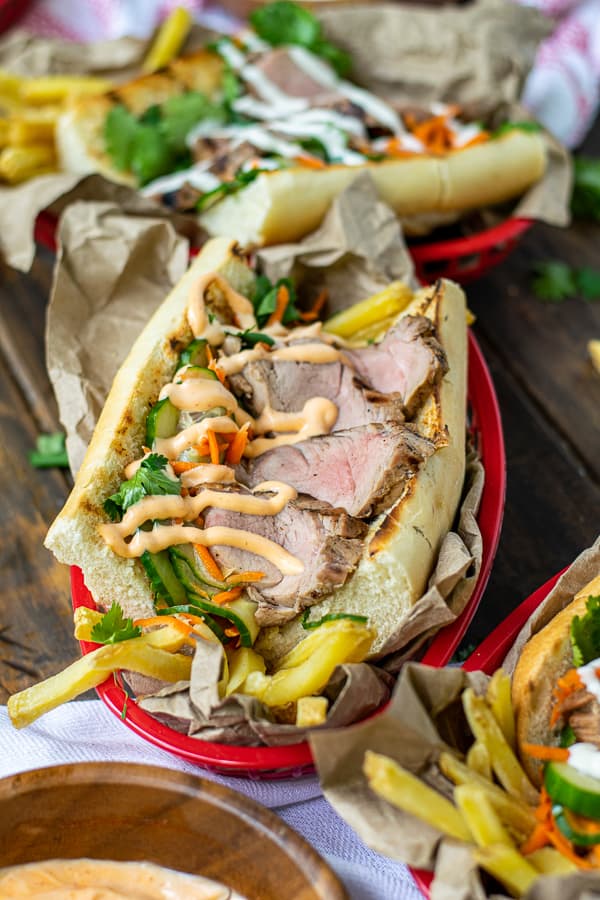 grilled pork tenderloin in a banh mi sandwich in a serving basket