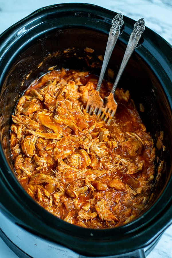 shredded bbq chicken in the crockpot with forks