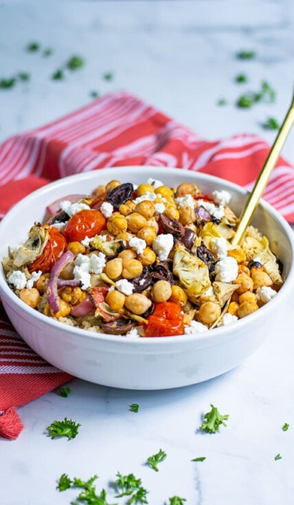 Healthy Chickpea Salad with Feta in a white bowl with a red napkin and gold spoon