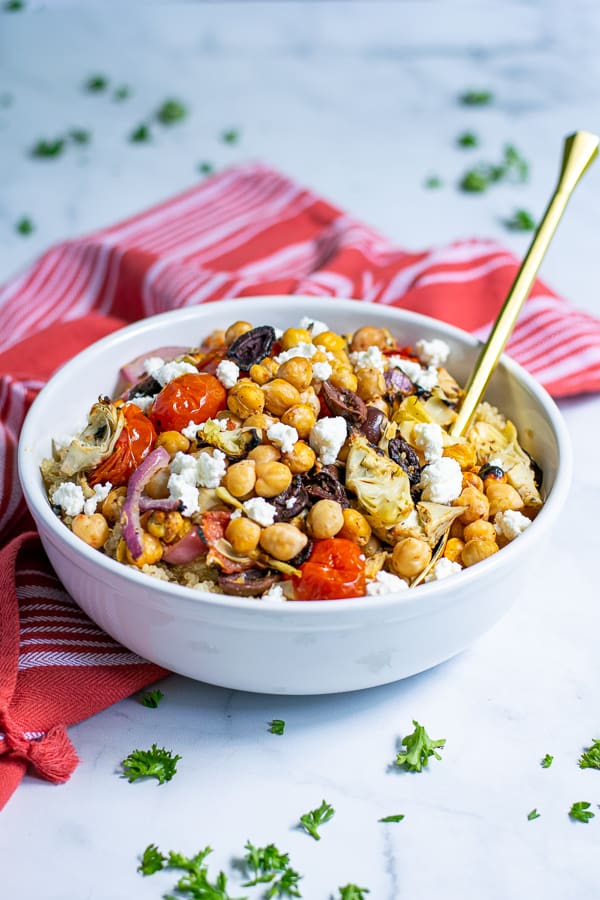 Healthy Chickpea Salad with Feta in a white bowl with a red napkin and gold spoon