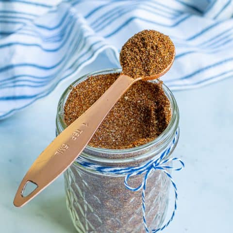 spoon full of taco seasoning simple resting on a jar full of taco seasoning