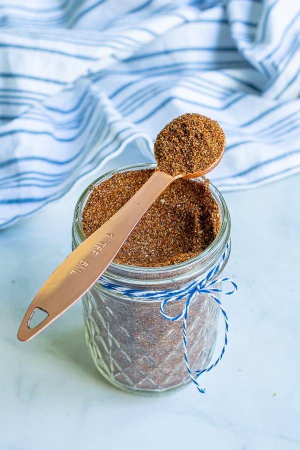 spoon full of taco seasoning simple resting on a jar full of taco seasoning