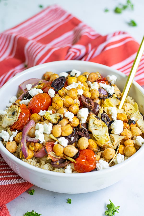 chickpea salad with feta in a white bowl with a spoon