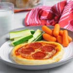 easy weeknight personal pizza on a white plate with vegetables is perfect for kids