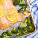 baked salmon and broccoli on a sheet pan with a bite on a fork