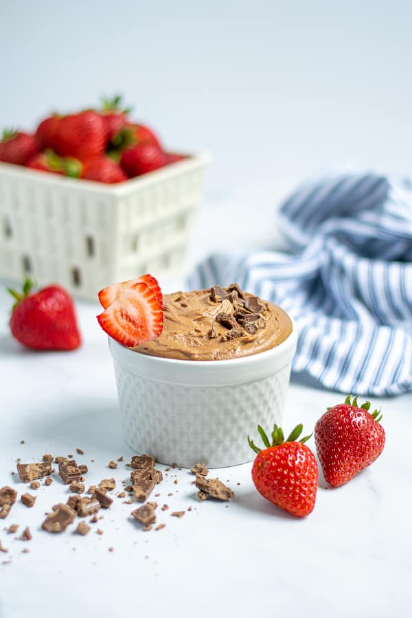 bowl of chocolate hummus with chocolate shavings and strawberries