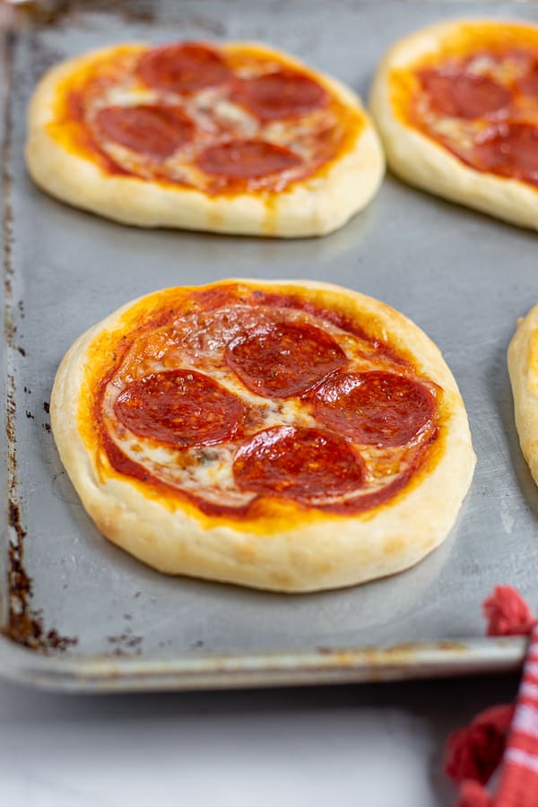 freshly baked pepperoni personal pizza on a sheet pan