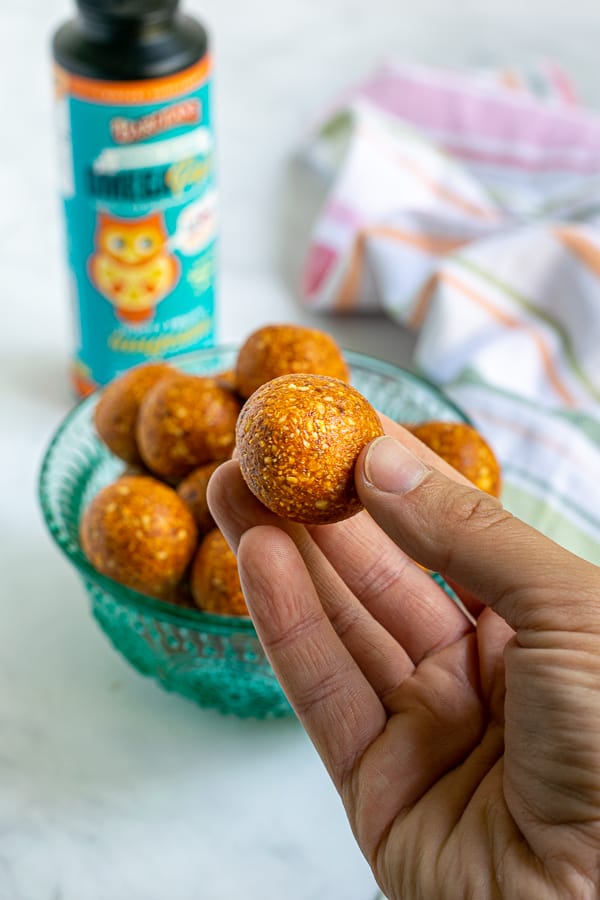 hand holding an orange tropical energy bite