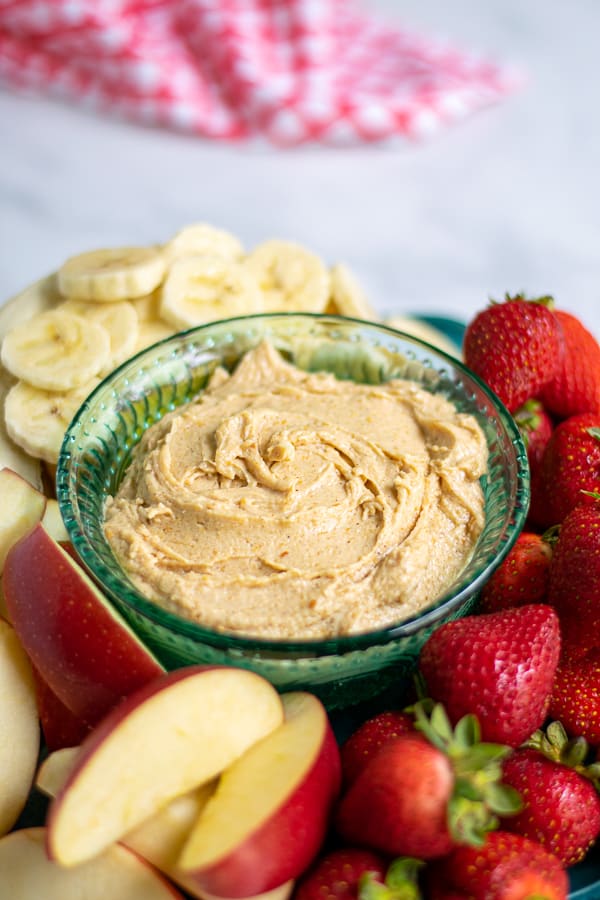 platter with peanut butter fruit dip surrounded by cut up fruit