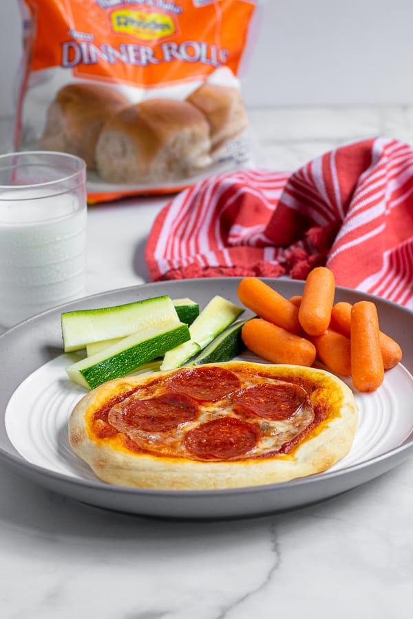 pepperoni personal pizza on a plate with vegetables