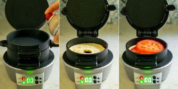 spraying a Hamilton Beach Sandwich Maker, placing in a bagel, and sliced tomatoes