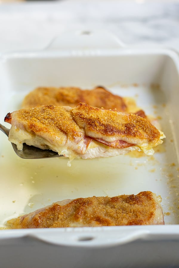 a serving piece holding a baked chicken cordon bleu