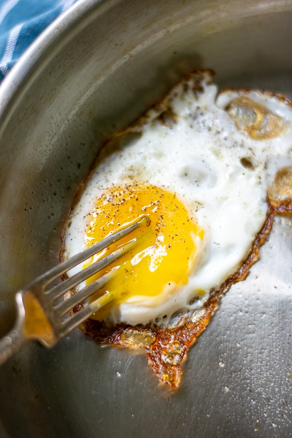 fork breaking a cooked egg yolk 