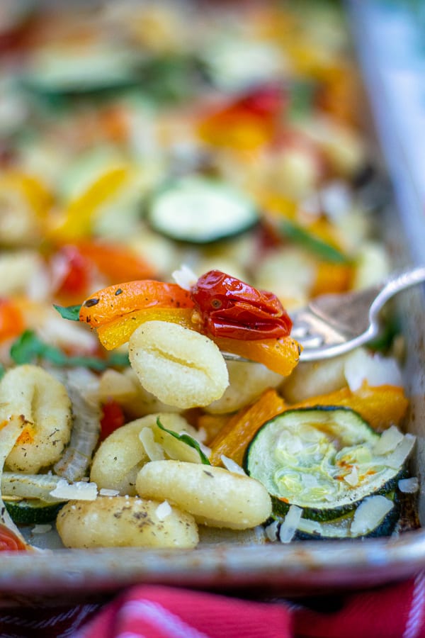 fork with a bite of gnocchi, peppers, and tomato