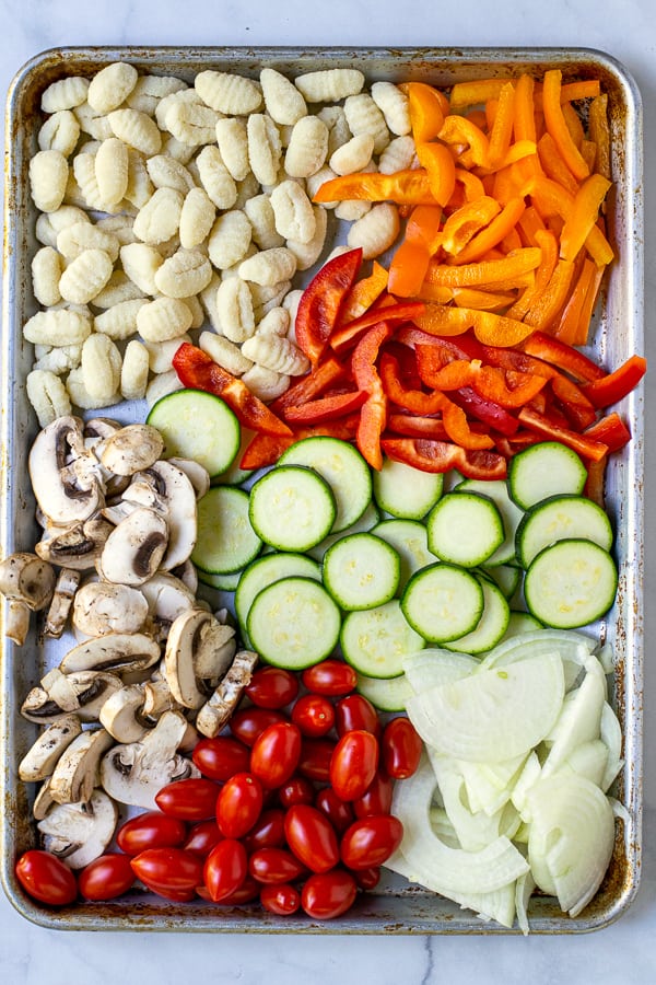 prepped vegetables and gnocchi on a sheet pan before getting tossed