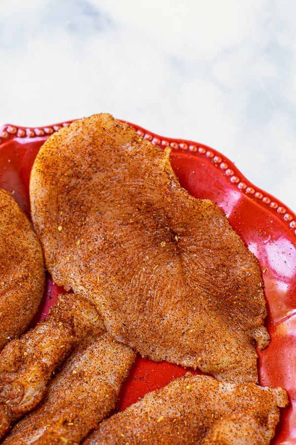 chicken cutlet coated in taco seasoning before being placed on the skillet