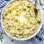large bowl of garlic mashed potatoes for a crowd with butter and a spoon