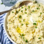instant pot garlic mashed potatoes for a crowd in a bowl with parsley and melted butter