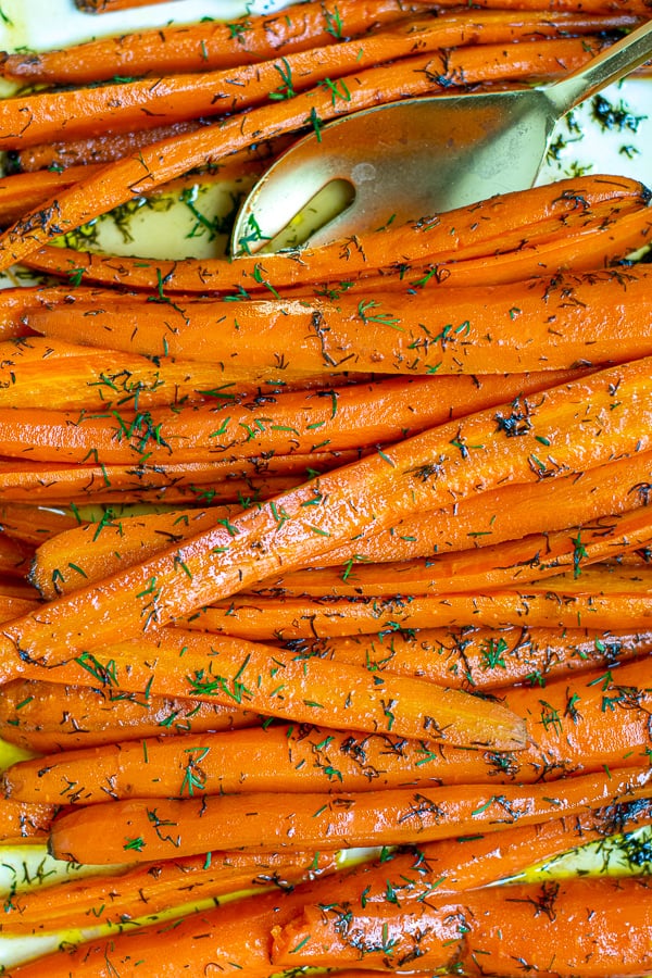 close up shot of the roasted carrots with a gold spoon