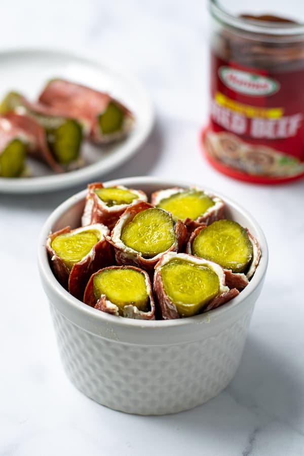 pickle roll ups with cream cheese and dried beef in a white bowl