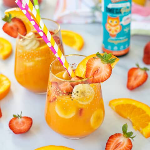 large glass of breakfast mocktail filled with fruits
