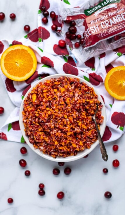 flatly of a bowl of cranberry orange relish with cranberries and oranges