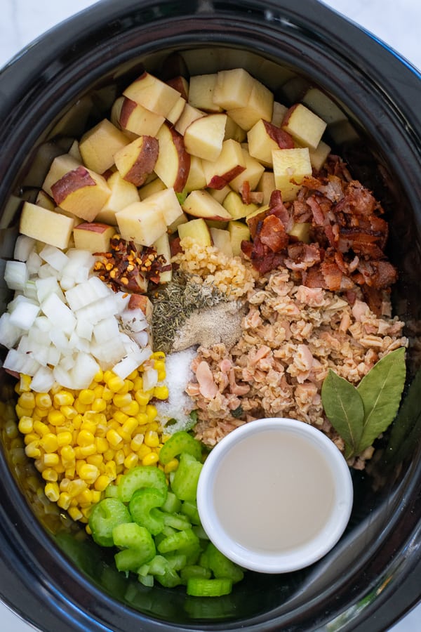 all of the ingredients laid out in a crockpot for clam chowder