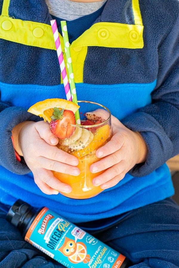young kids holding an orange juice mocktail
