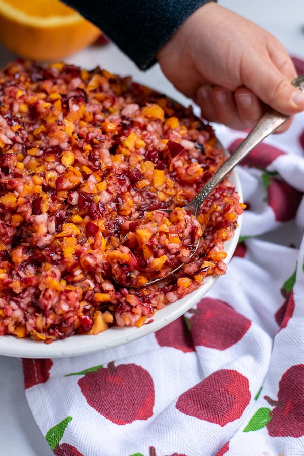 kid hand with spoon taking a scoop of cranberry orange relish