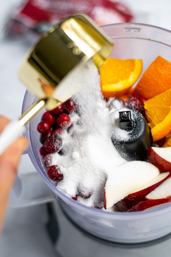 sugar being poured into the food processor to make the relish