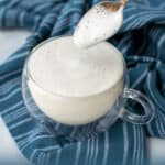 a spoon filled with foam over a kid-friendly latte