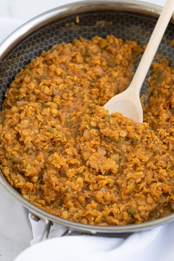 red lentil taco 'meat' in a large frying pan with a spoon