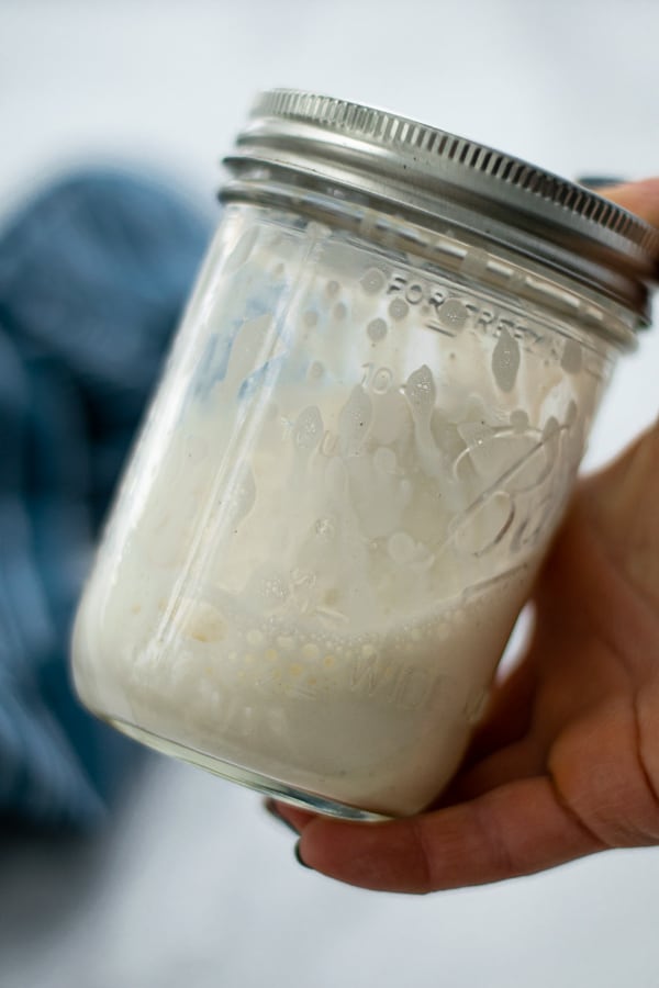 shaking a glass jar full of milk to make the foam