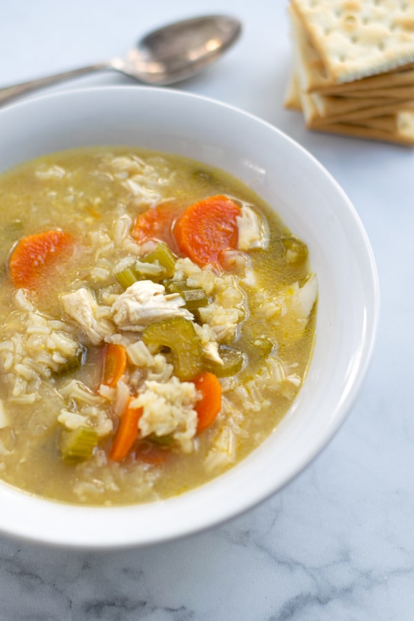 bowl filled with chicken rice soup showing off chicken, rice, and vegetables 