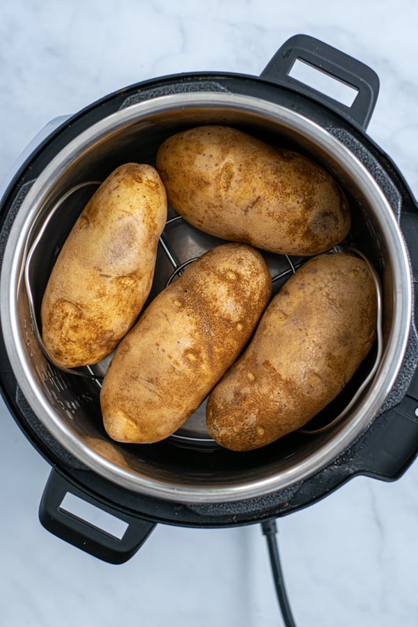 pressure cooker with raw potatoes on a trivet