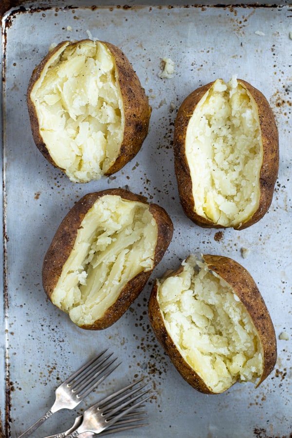 Tray full of freshly sliced open crispy baked potatoes