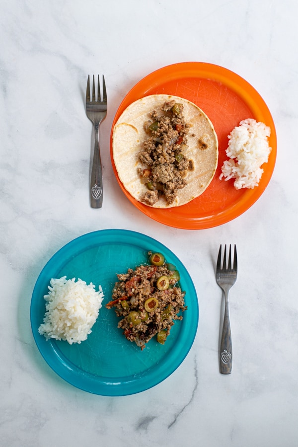 2 plastic kids plates showing two different ways to serve picadillo to kids