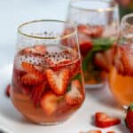 pink rosé sangria on a tray made with strawberries and basil