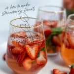 heart shaped strawberries in a glass of rosé sangria