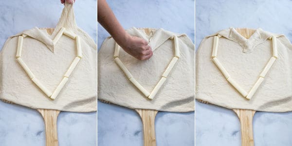 pizza dough on the outside of the cheese heart being pulled over the string cheese