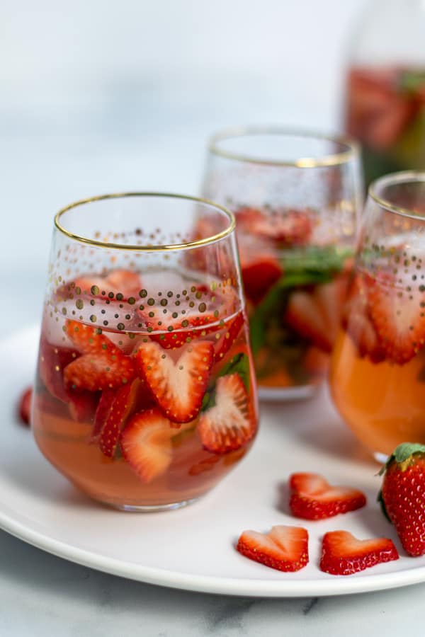 glasses of strawberry sangria with heart shaped strawberries and basil perfect for Valentine's Day, brunches, and bridal showers